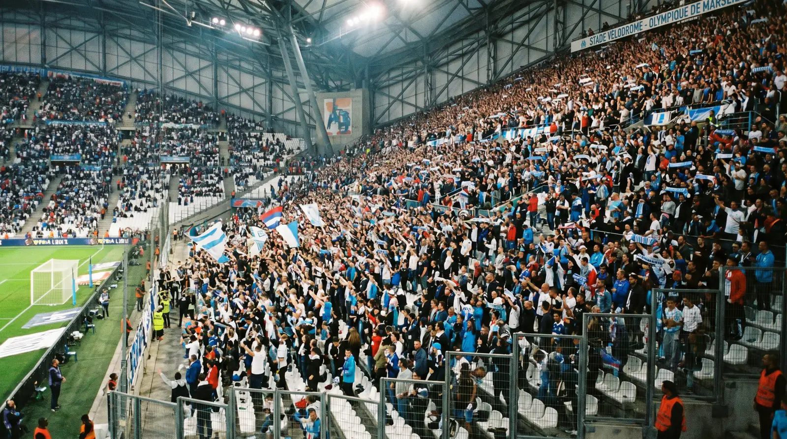 Supporters enthousiastes dans les tribunes d'un stade de Ligue 1 encourageant leur équipe à domicile